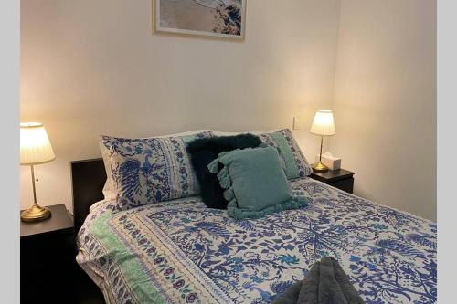 1 dormitorio con 1 cama con almohadas y 2 lámparas en DELUXE CLOSE TO CITY WIFI NETFLIX WINE PARKING en Perth