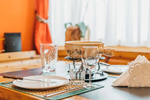a table with plates and glasses on a table at Charming 4 bed flat in Flims in Flims
