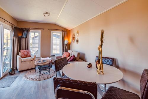 a living room with a table and chairs at Chalet park Kroondomein Giethoorn in Giethoorn