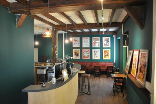 un bar dans un restaurant avec des murs et des chaises verts dans l'établissement Hostel20 Bayonne, à Bayonne