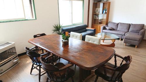 a living room filled with furniture and a table at Kawayu Onsen Guesthouse NOMY in Kawayu