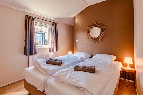 a bedroom with a large bed with two pillows on it at Chalet park Kroondomein Giethoorn in Giethoorn