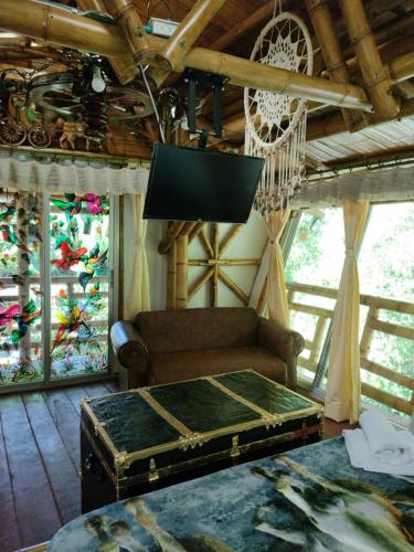 a living room with a couch and a flat screen tv at Hospedaje Rural Tupinamba in Ibagué