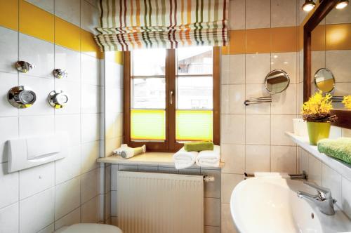 a bathroom with a sink and a toilet and a window at Wohlfühl-Ferienwohnungen Schneider in Bad Hindelang