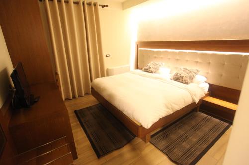 a bedroom with a bed and a television in it at Hotel Alpin Llogara in Llogara