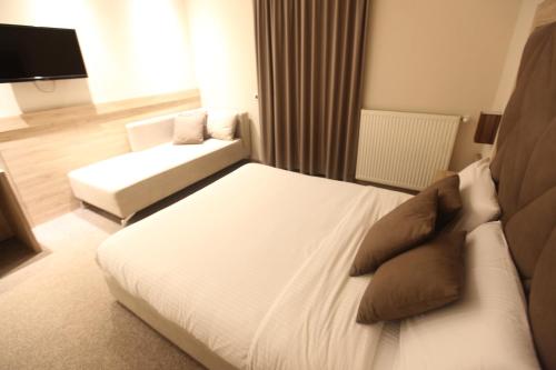 a hotel room with a bed and a couch at Hotel Alpin Llogara in Llogara
