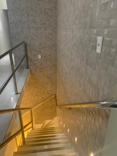 a staircase in a room with a brick wall at Pousada Mariluz in Maragogi