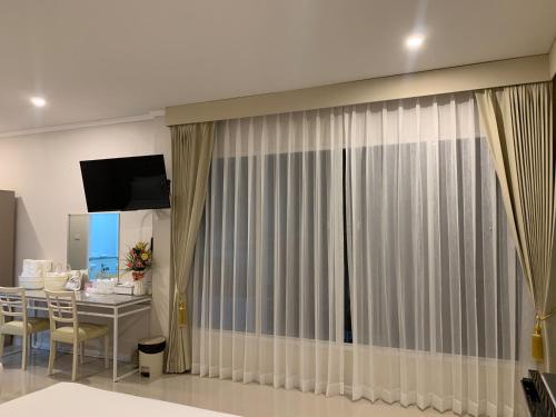 a room with a table and a curtain at Siri Ville Hotel in Si Sa Ket