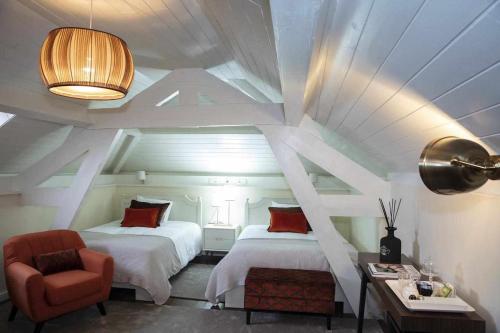 a bedroom with two beds and a chair and a table at Casa da Granja - Boutique in Vila Nova de Gaia