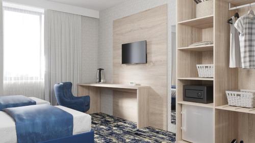 a hotel room with a bed and a desk and a tv at Hotel Aviator Sheremetyevo in Moscow