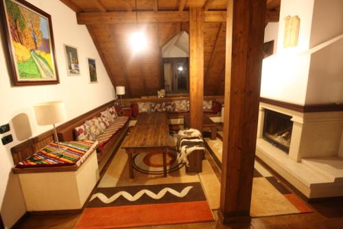 a living room with a couch and a table and a fireplace at Hotel Alpin Llogara in Llogara