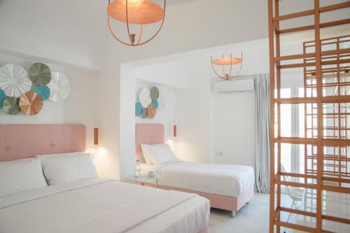 a bedroom with two beds and a ladder at Nama Boutique Hotel in Tinos Town