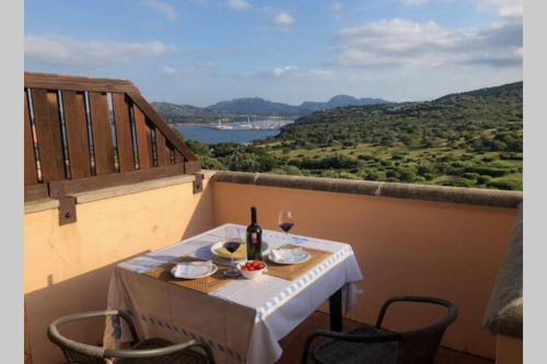 a table with a bottle of wine on a balcony at Appartamento Portisco sul Mare in Olbia