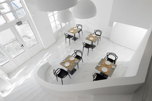 uitzicht op een restaurant met tafels en stoelen bij Nama Boutique Hotel in Tinos Town