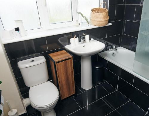 ein Badezimmer mit einem weißen WC und einem Waschbecken in der Unterkunft Ser Ar Y Bryn- Lovely family home with garden, walk to the village and beach in Saundersfoot