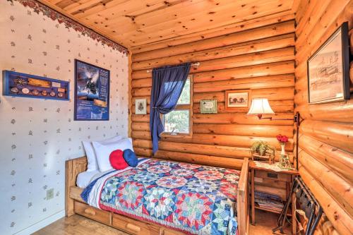 Un dormitorio con una cama en una cabaña de troncos en Quaint Williams Cabin Near Grand Canyon, en Williams