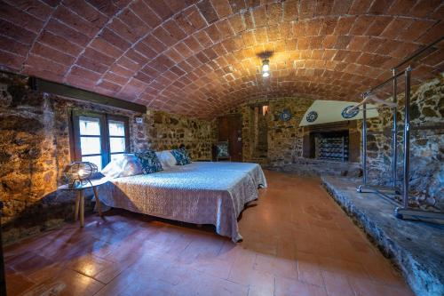 a bedroom with a large bed in a stone room at Castillo Can Xirau Piscina Privada Vistas Mar Aire Acondicionado in Santa Susanna