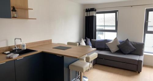 eine Küche und ein Wohnzimmer mit einem Tisch und einer Couch in der Unterkunft Sleeps 6 Centre of Portrush, Main street, Coastal Links in Portrush