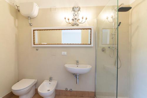 a bathroom with a sink and a toilet and a glass shower at Agriturismo SS Annunziata in San Vincenzo