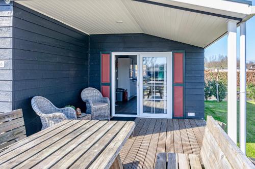 a patio with a wooden table and chairs and a door at Chalet park Kroondomein Giethoorn in Giethoorn
