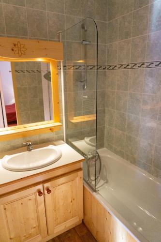 une salle de bain avec un lavabo, une baignoire et une douche dans l'établissement Résidence Goélia Les Terrasses du Corbier, au Corbier