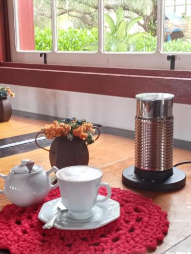 a table with a tea pot and a cup on a rug at Pousada Araujo Bazilio in Tiradentes
