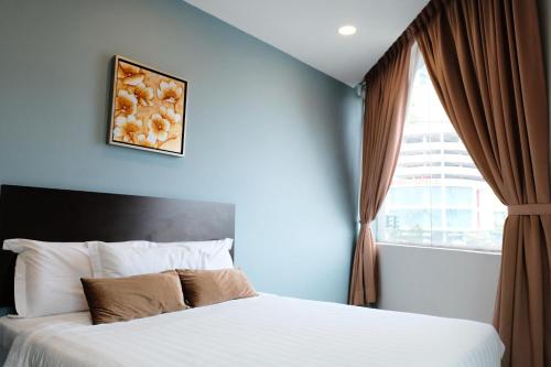 a bedroom with a large bed and a window at De Era Hotel in Seri Kembangan