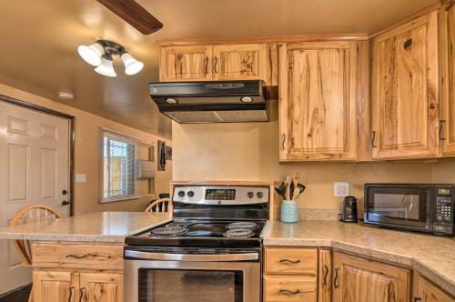 a kitchen with wooden cabinets and a stove top oven at Cozy Home with Canyon Views 2 Mi to Grand Staircase in Henrieville