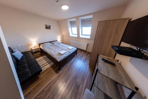 a small room with a bed and a couch at Megálló Wellness Panzió in Pálháza