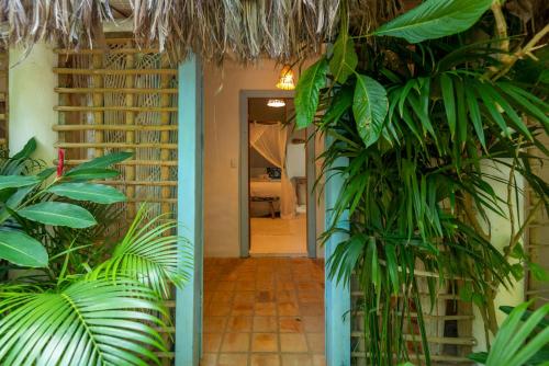 a hallway with green plants in a room with a doorway at Casa da Glória Trancoso - Pousada Boutique in Trancoso
