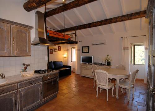 cocina y sala de estar con mesa y sillas en Latu Corsu - Côté Corse - Gites et chambres d'hôtes au Cap Corse, en Ersa