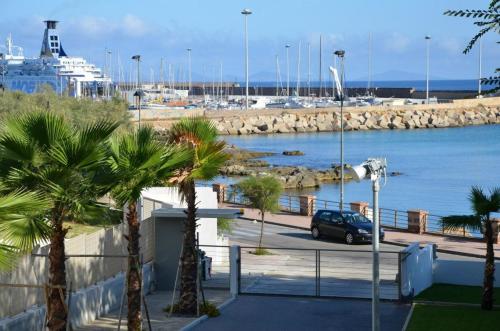 un coche aparcado junto a un puerto deportivo con un crucero en Boutique Lungomare en Porto Torres