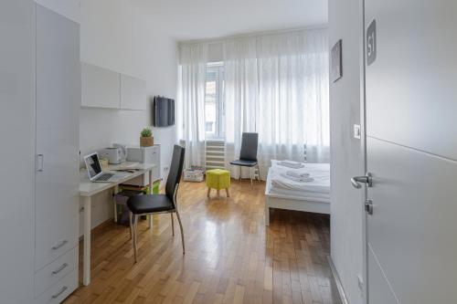 a white room with a desk and a bed at Stars of Zagreb Apartments in Zagreb