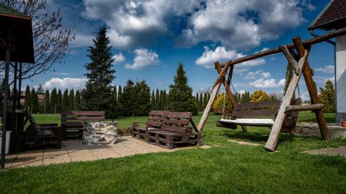 a group of benches sitting in a park at Megálló Wellness Panzió in Pálháza