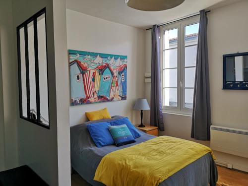 a bedroom with a bed and a painting on the wall at Le studio de Line in Rochefort
