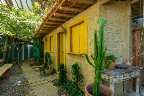a house with a yellow door and some plants at Casa da Glória Trancoso - Pousada Boutique in Trancoso