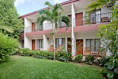a building with chairs and a lawn in front of it at Hotel Boyeros in Liberia
