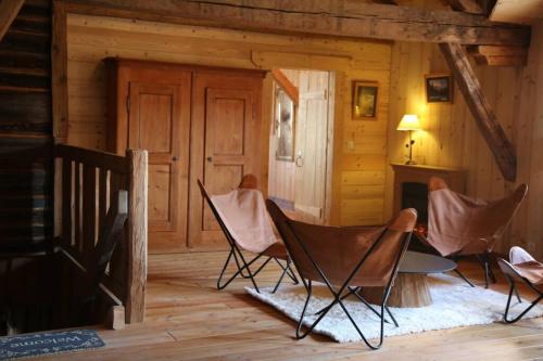 a room with chairs and a fireplace in a cabin at La Grande Marguerite in Les Fourgs