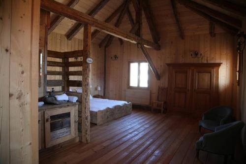 a bedroom with a bed in a wooden house at La Grande Marguerite in Les Fourgs