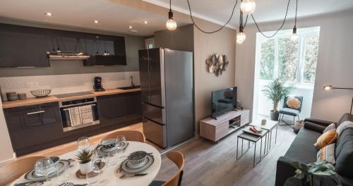 a kitchen and living room with a table and a refrigerator at Le joyau de Belledonne in Chambéry