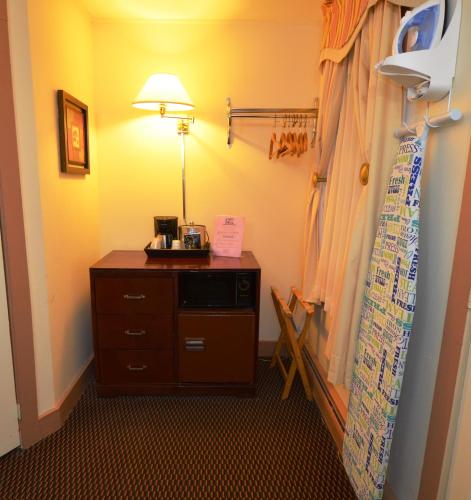 a room with a lamp and a dresser in a room at Williamstown Motel in Williamstown