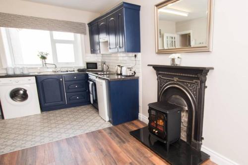 a kitchen with a fireplace and a stove at Atlantic View Apartment in Dungloe