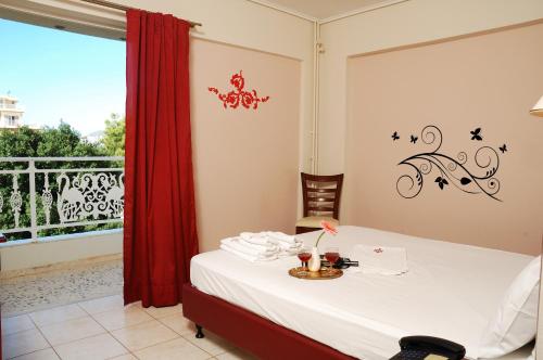 a room with a bed with a table and a window at Ilion in Loutraki