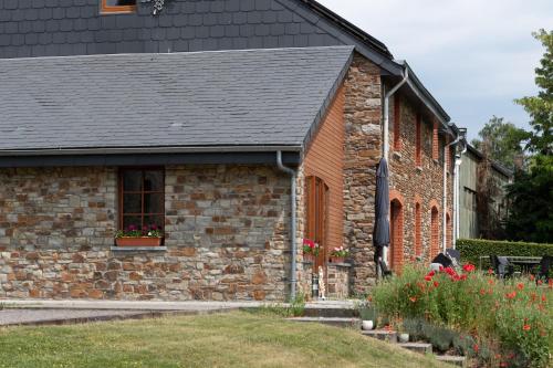 a brick building with a black roof at Chanteloup, Maison d'hotes - Halleux in Halleux