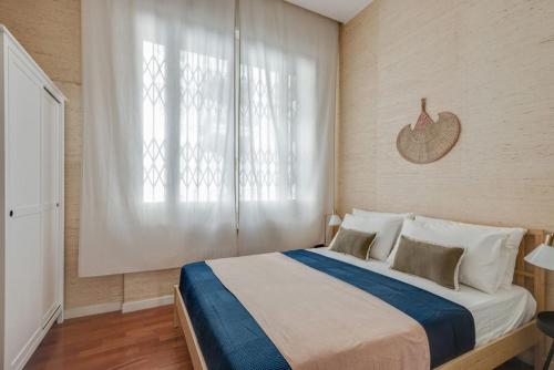 a bedroom with a large bed with a large window at Central amazing flat Repubblica Central station in Milan