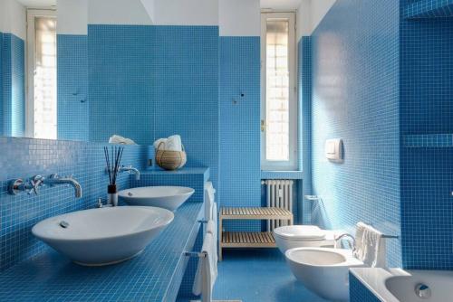 a blue bathroom with two sinks and two toilets at Central amazing flat Repubblica Central station in Milan