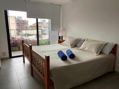 two blue slippers sitting on a bed in a bedroom at B&B Mono ambiente in San Miguel de Tucumán