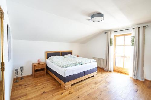 um quarto com uma cama e piso em madeira em Bergblick Acht Mondsee em Innerschwand