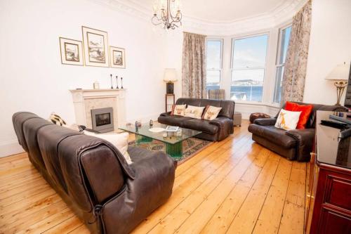 a living room with leather furniture and a fireplace at Apartment 'Invertay' Newport on Tay, 15 Minute Drive to St Andrews Golf in Fife