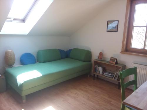 een woonkamer met een groene bank en een tafel bij das Vogelnest in Maierhöfen